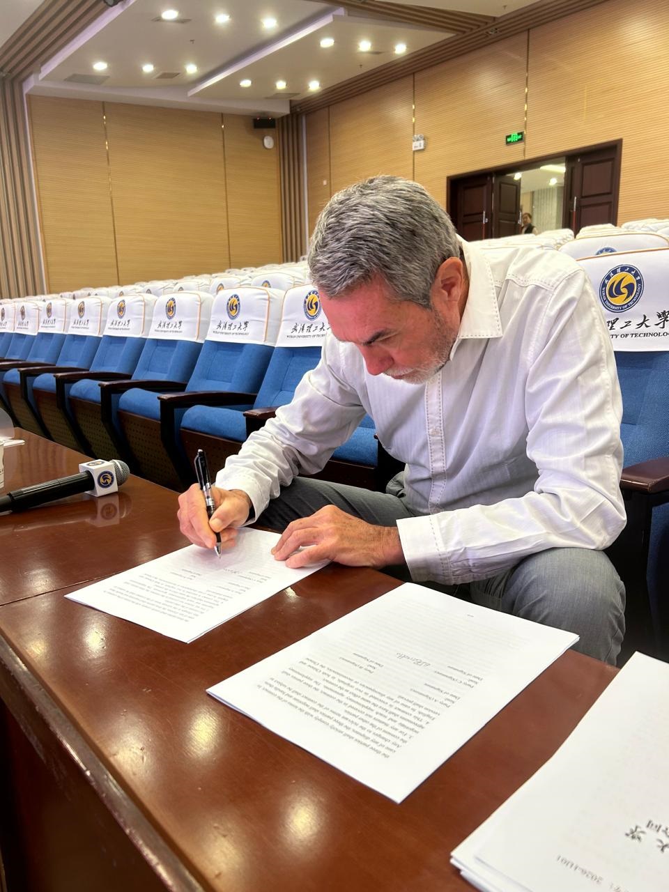 O professor durante a assinatura do contrato com a Universidade de Wuhan: trabalhos começam oficialmente ainda em outubro próximo, focados em projetos industriais de interesse comum