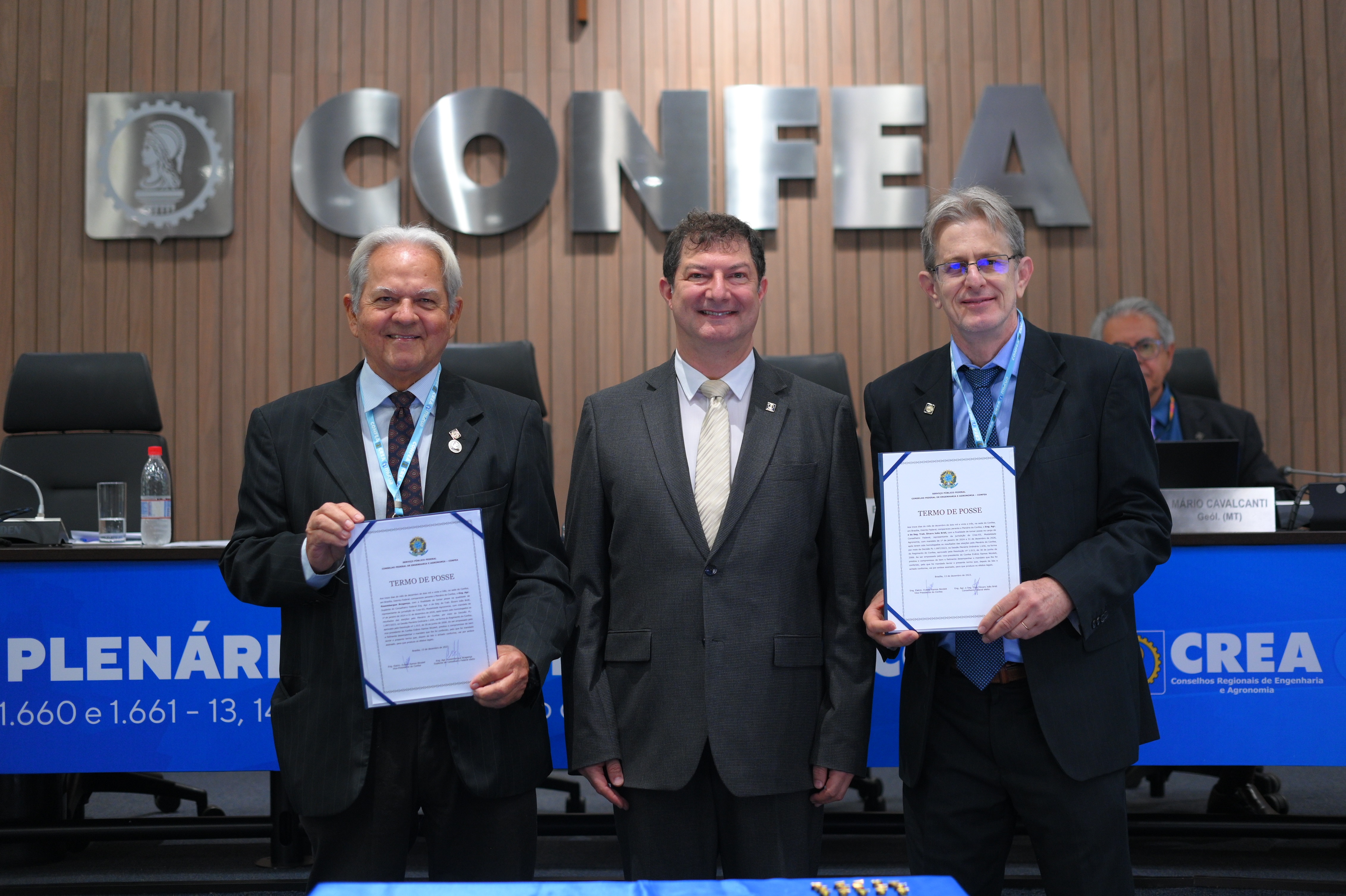 Engenheiros agrônomos Rosembergue Bragança (suplente) e João Bridi (titular) recebem certificado de posse acompanhados pelo vice-presidente Evânio Nicoleit